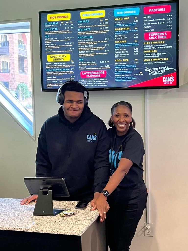 Cam and Latasha together behind the counter at Cam's Coffee
