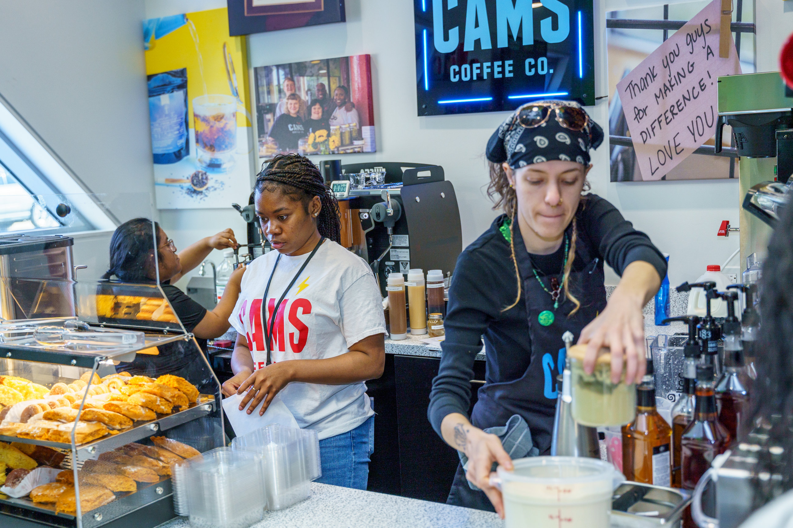A diverse Cam's Coffee team working behind the counter